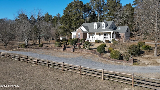 view of front of house with a rural view and a porch