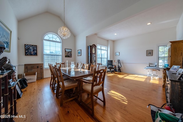 dining room with vaulted ceiling, a chandelier, and light hardwood / wood-style floors