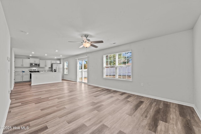 unfurnished living room featuring ceiling fan and light hardwood / wood-style floors