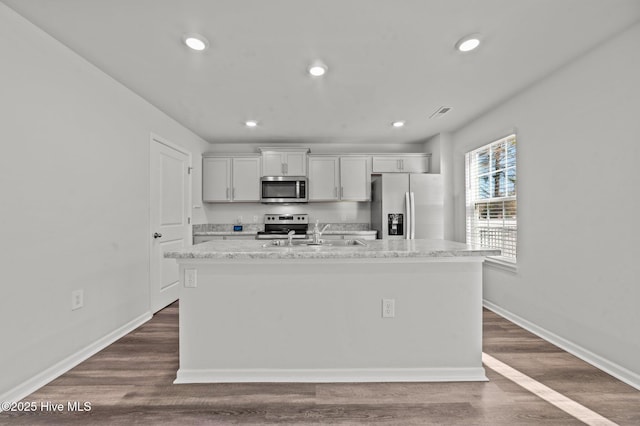 kitchen with sink, white cabinetry, stainless steel appliances, and an island with sink