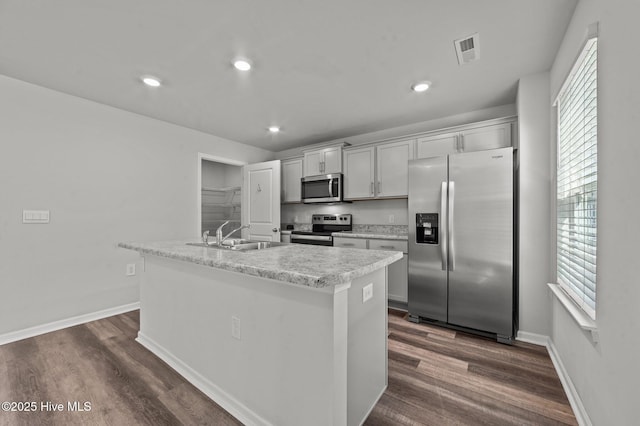 kitchen featuring sink, a kitchen island with sink, appliances with stainless steel finishes, and dark wood-type flooring