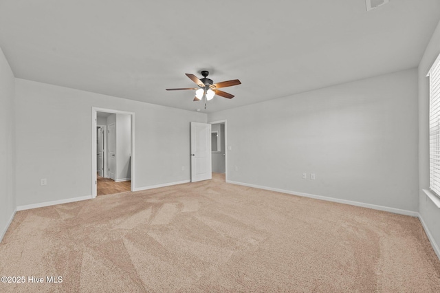 carpeted spare room with a wealth of natural light and ceiling fan