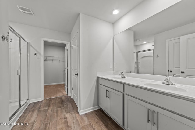 bathroom featuring hardwood / wood-style floors, vanity, and walk in shower