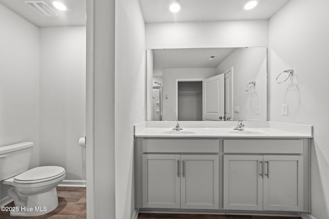 bathroom with hardwood / wood-style floors, vanity, and toilet