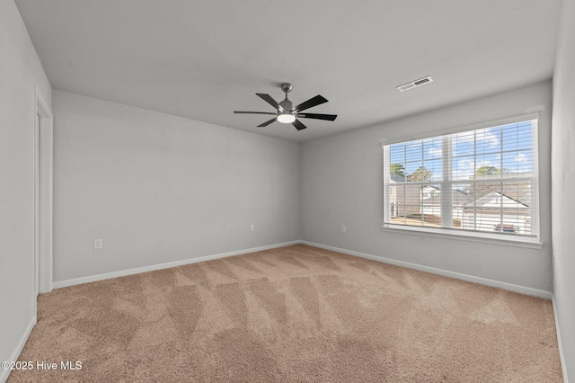 empty room featuring ceiling fan and carpet