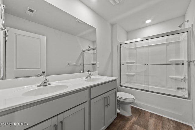 full bathroom with shower / bath combination with glass door, toilet, vanity, and hardwood / wood-style flooring