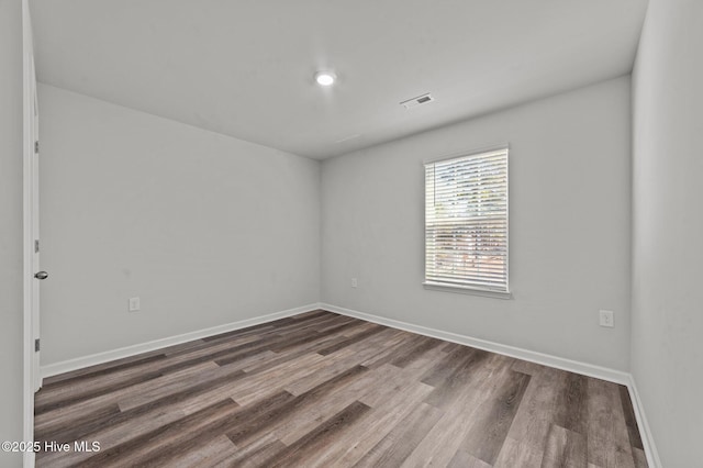 spare room featuring dark wood-type flooring