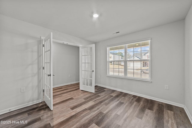 unfurnished bedroom with french doors and dark wood-type flooring