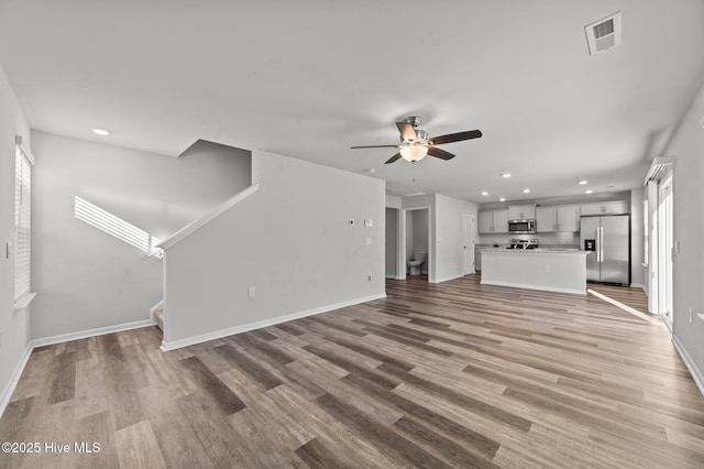 unfurnished living room with ceiling fan and light hardwood / wood-style flooring