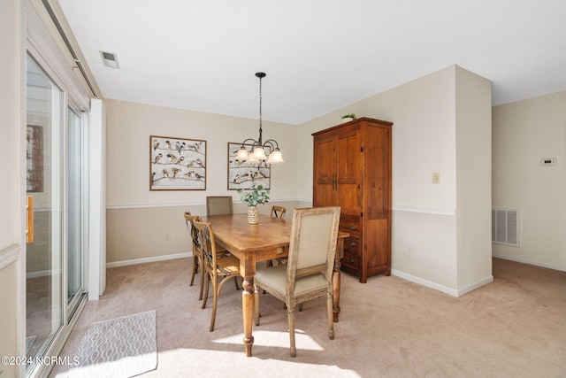 carpeted dining area with a chandelier