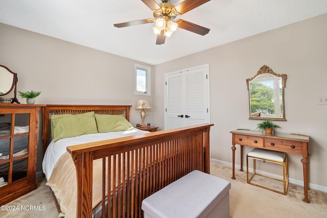 bedroom featuring light colored carpet, a closet, and ceiling fan