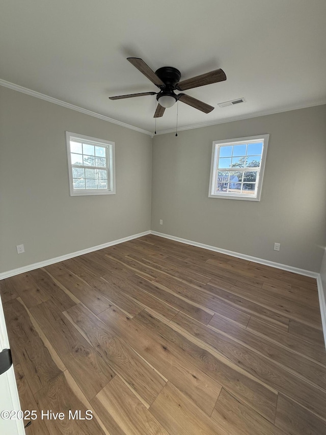 empty room with crown molding, plenty of natural light, ceiling fan, and wood-type flooring