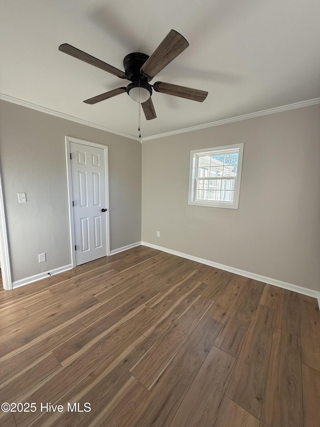 empty room with dark hardwood / wood-style floors, ceiling fan, and ornamental molding