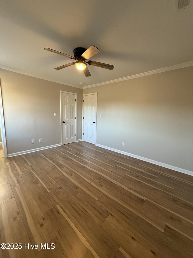 unfurnished bedroom with ceiling fan, ornamental molding, and dark wood-type flooring