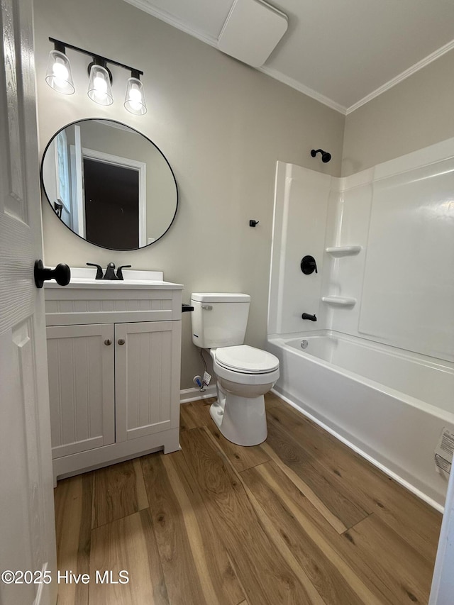 full bathroom featuring hardwood / wood-style floors, vanity, bathing tub / shower combination, crown molding, and toilet