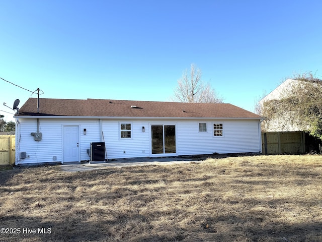 back of house with central AC and a lawn