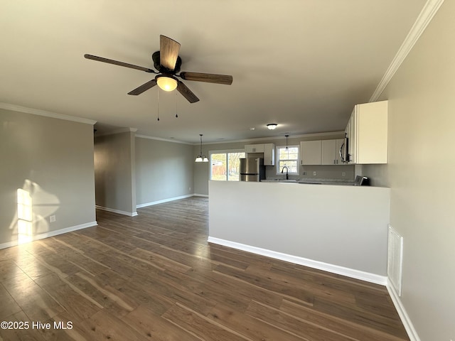 unfurnished living room with crown molding, sink, ceiling fan with notable chandelier, and dark hardwood / wood-style floors