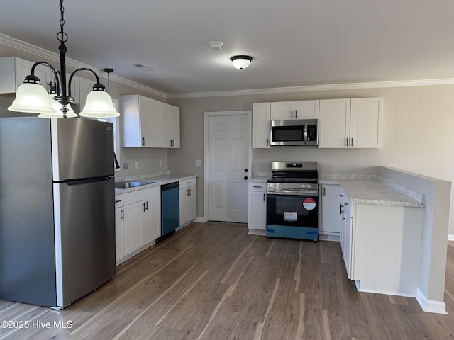 kitchen with hardwood / wood-style floors, stainless steel appliances, white cabinetry, and pendant lighting