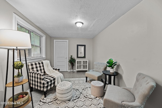 living area with light tile patterned floors and a textured ceiling