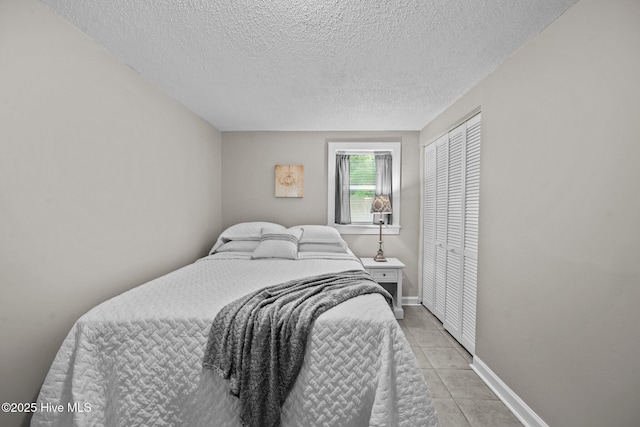 tiled bedroom featuring a textured ceiling and a closet