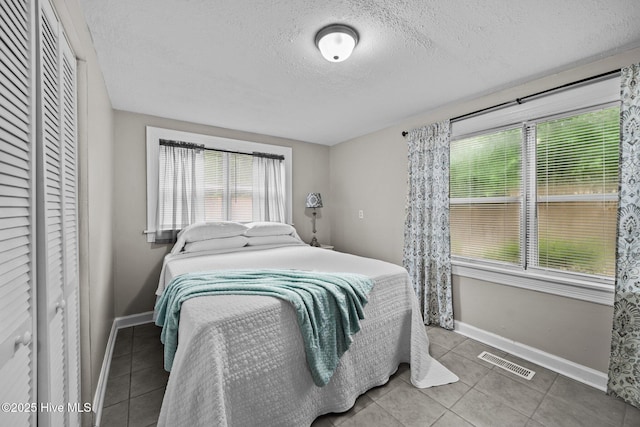 bedroom featuring tile patterned floors and a textured ceiling