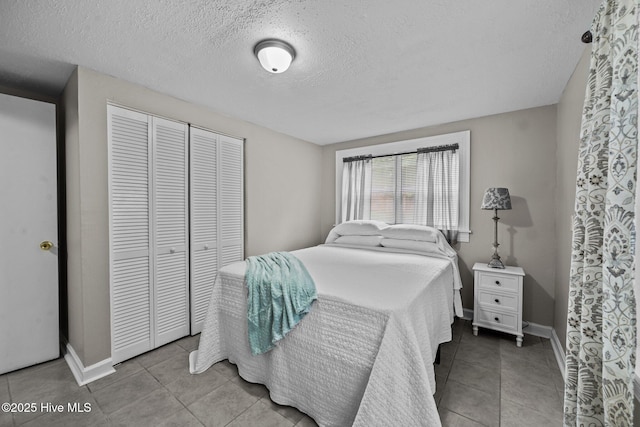 tiled bedroom featuring a textured ceiling and a closet