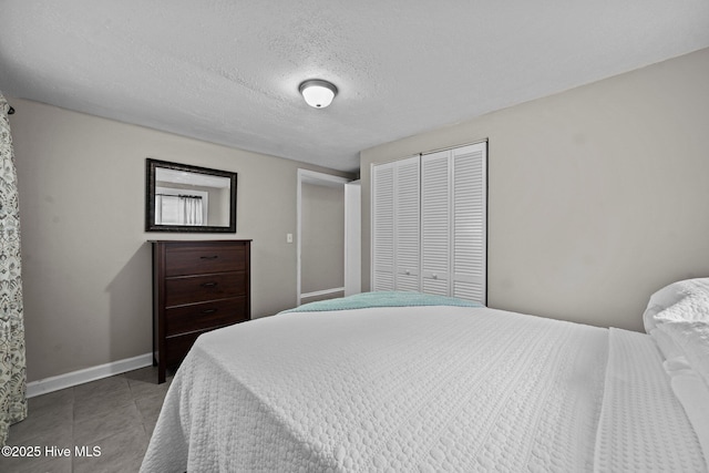 bedroom with a textured ceiling and a closet