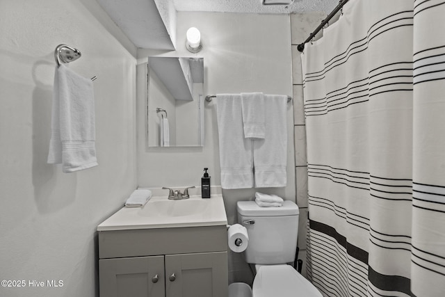 bathroom featuring vanity, toilet, a textured ceiling, and walk in shower