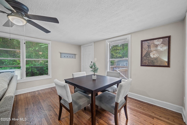 dining room featuring a textured ceiling, ceiling fan, and dark wood-type flooring