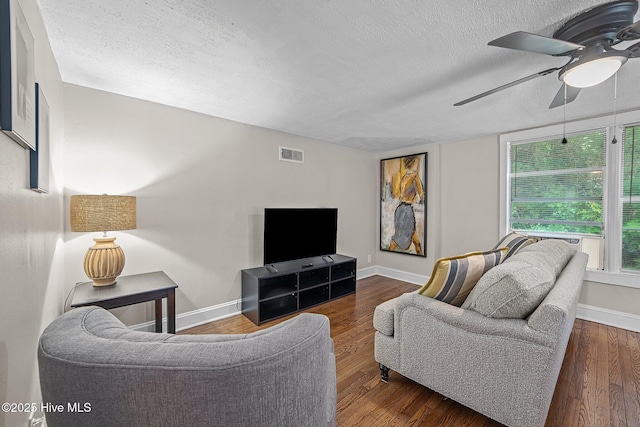 living room featuring a textured ceiling, dark hardwood / wood-style flooring, and ceiling fan