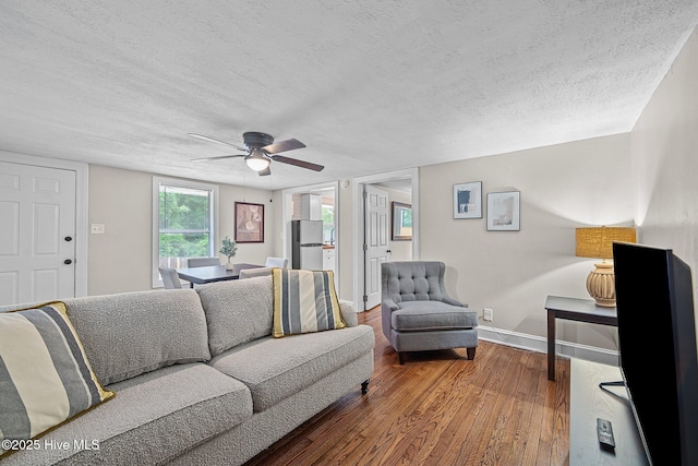 living room with hardwood / wood-style floors, a textured ceiling, and ceiling fan