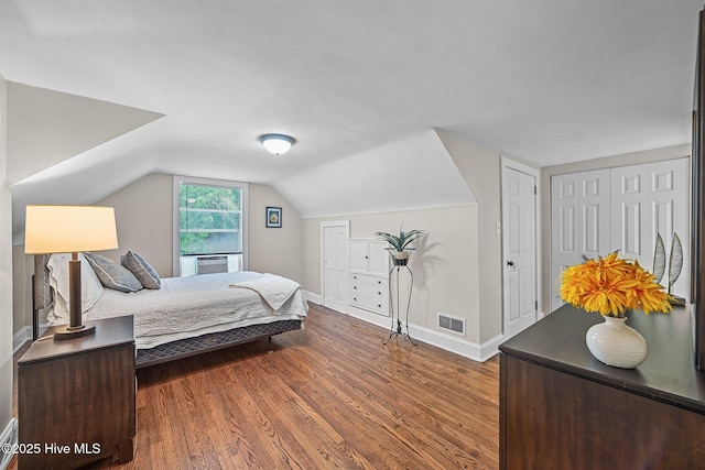 bedroom featuring dark hardwood / wood-style flooring and vaulted ceiling