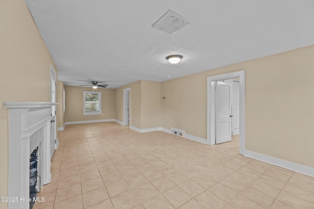 unfurnished living room featuring ceiling fan and a textured ceiling