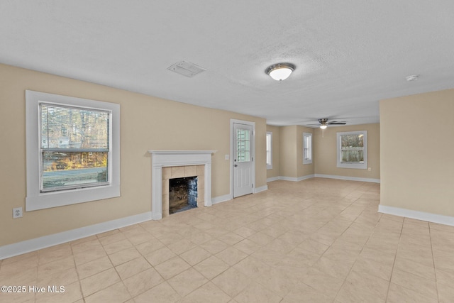 unfurnished living room featuring a fireplace, a textured ceiling, and ceiling fan