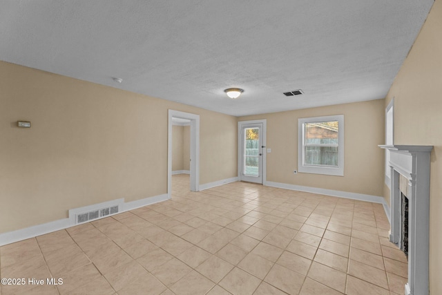 unfurnished living room with light tile patterned floors and a textured ceiling