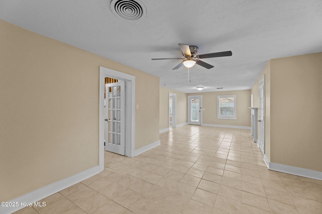 tiled empty room with a textured ceiling and ceiling fan