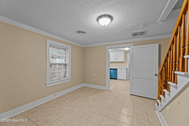 empty room featuring crown molding and a textured ceiling