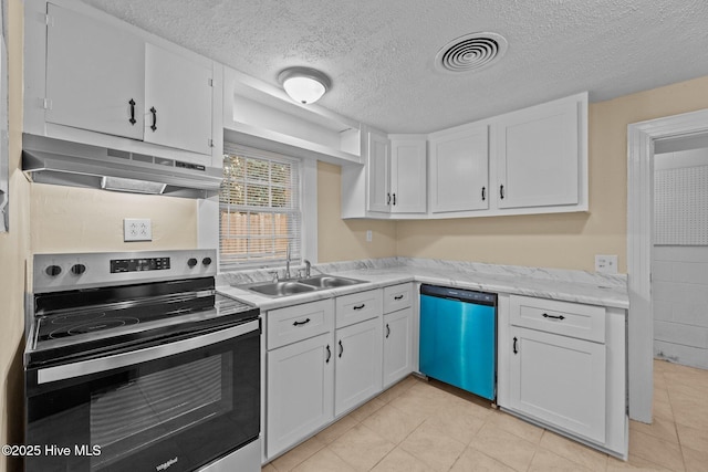 kitchen with a textured ceiling, stainless steel appliances, sink, light tile patterned floors, and white cabinetry