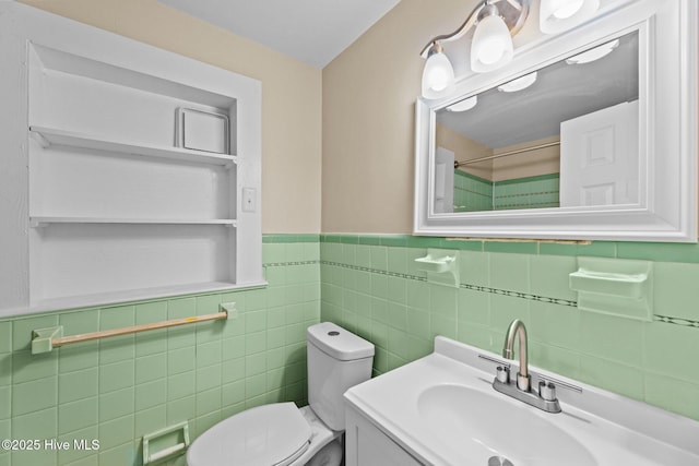 bathroom featuring vanity, tile walls, and toilet