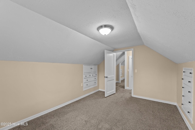 bonus room with carpet flooring, a textured ceiling, vaulted ceiling, and built in features