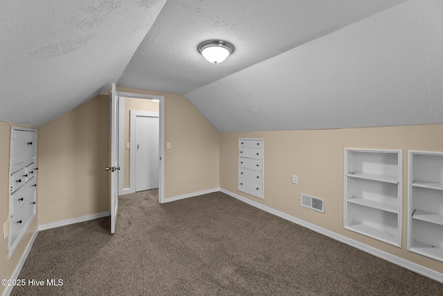 bonus room with carpet flooring, a textured ceiling, built in features, and vaulted ceiling