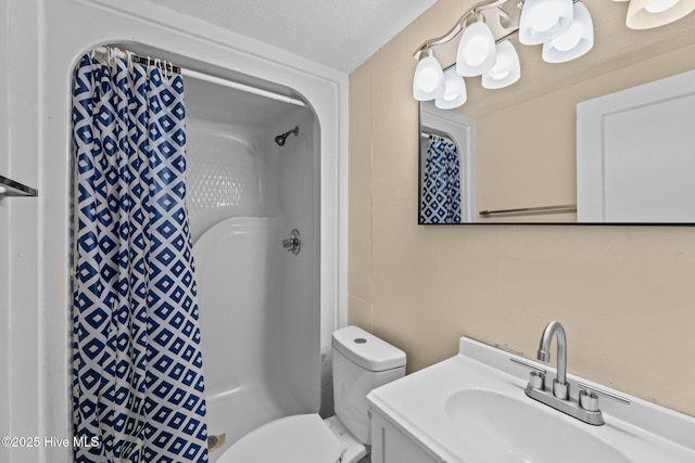 bathroom with vanity, toilet, a shower, and a textured ceiling