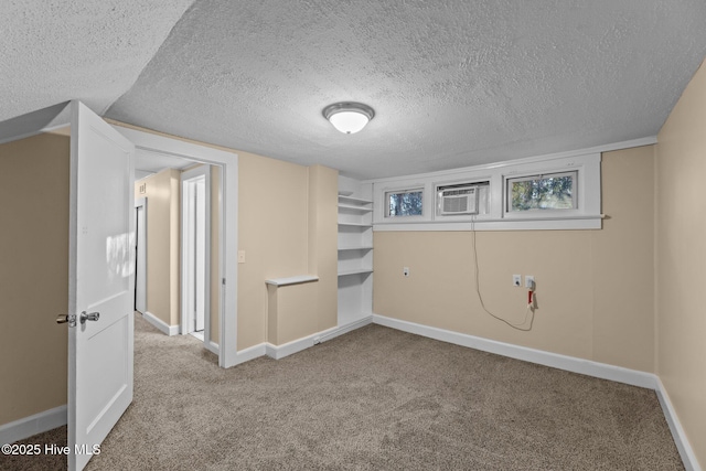 interior space featuring carpet, a textured ceiling, and a wall unit AC