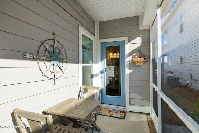 property entrance featuring covered porch and cooling unit