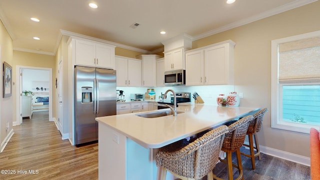 kitchen with kitchen peninsula, appliances with stainless steel finishes, and white cabinetry