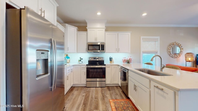 kitchen with white cabinetry, sink, stainless steel appliances, and light hardwood / wood-style flooring