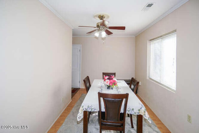 dining area featuring light wood-type flooring, ceiling fan, and ornamental molding