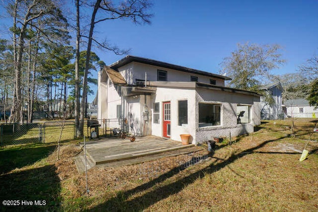 rear view of property featuring a deck and a yard