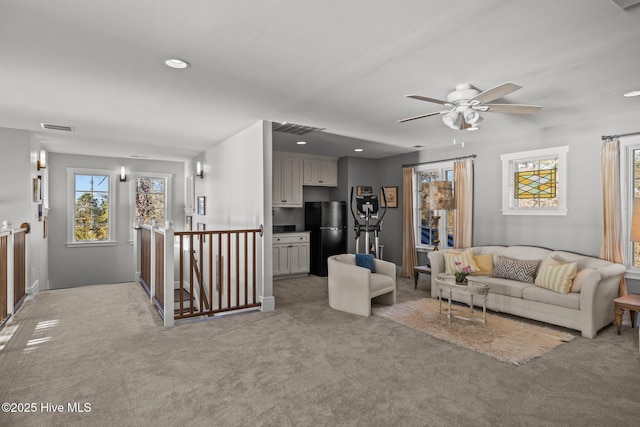 carpeted living room with ceiling fan