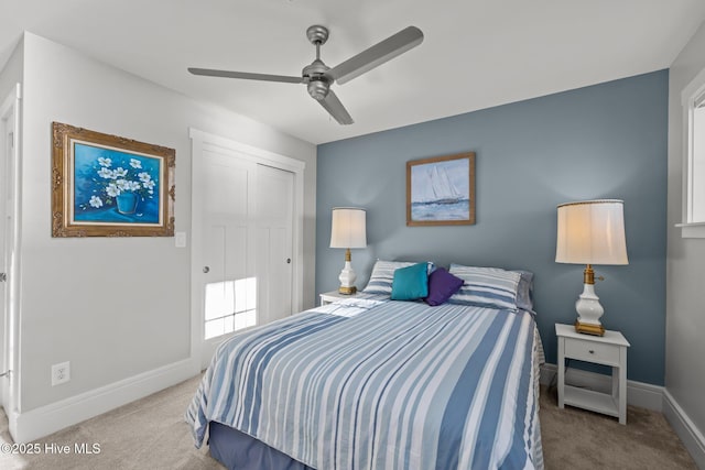 carpeted bedroom featuring ceiling fan and a closet